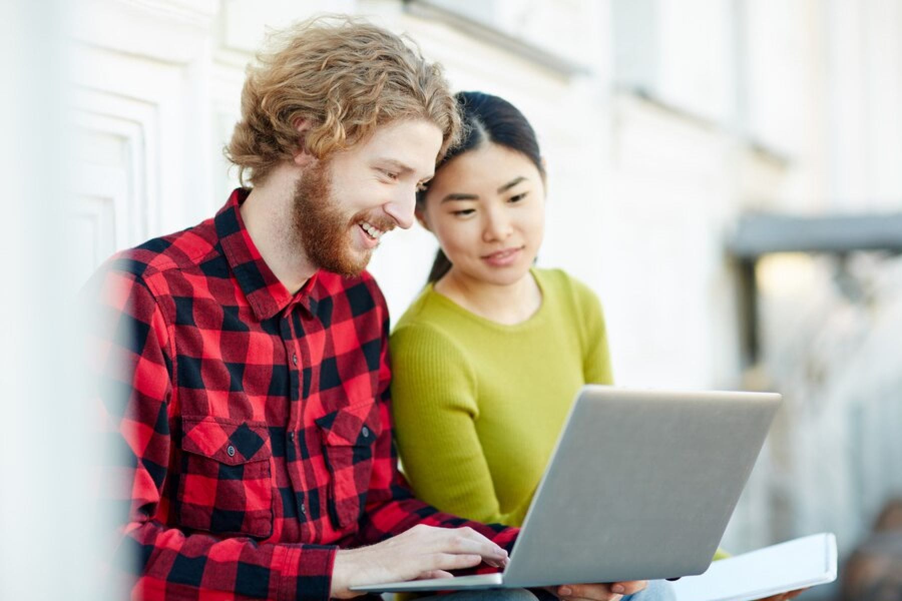 man and woman looking at the laptop screen